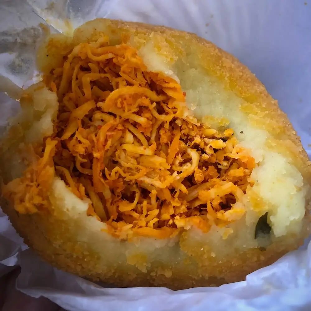 Shredded chicken surrounded by a potato dough and breadcrumbs