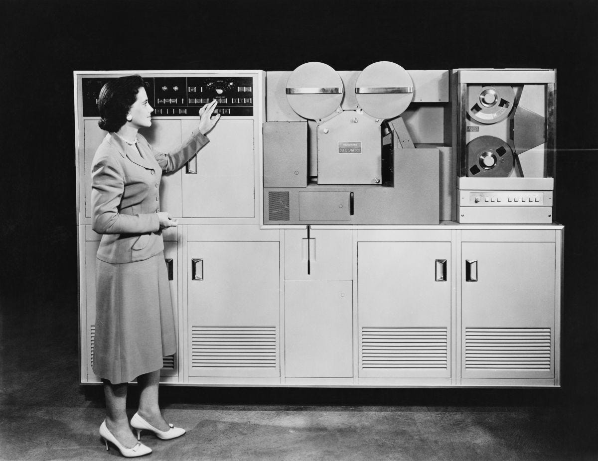 1950s mainframe computer with woman operating it