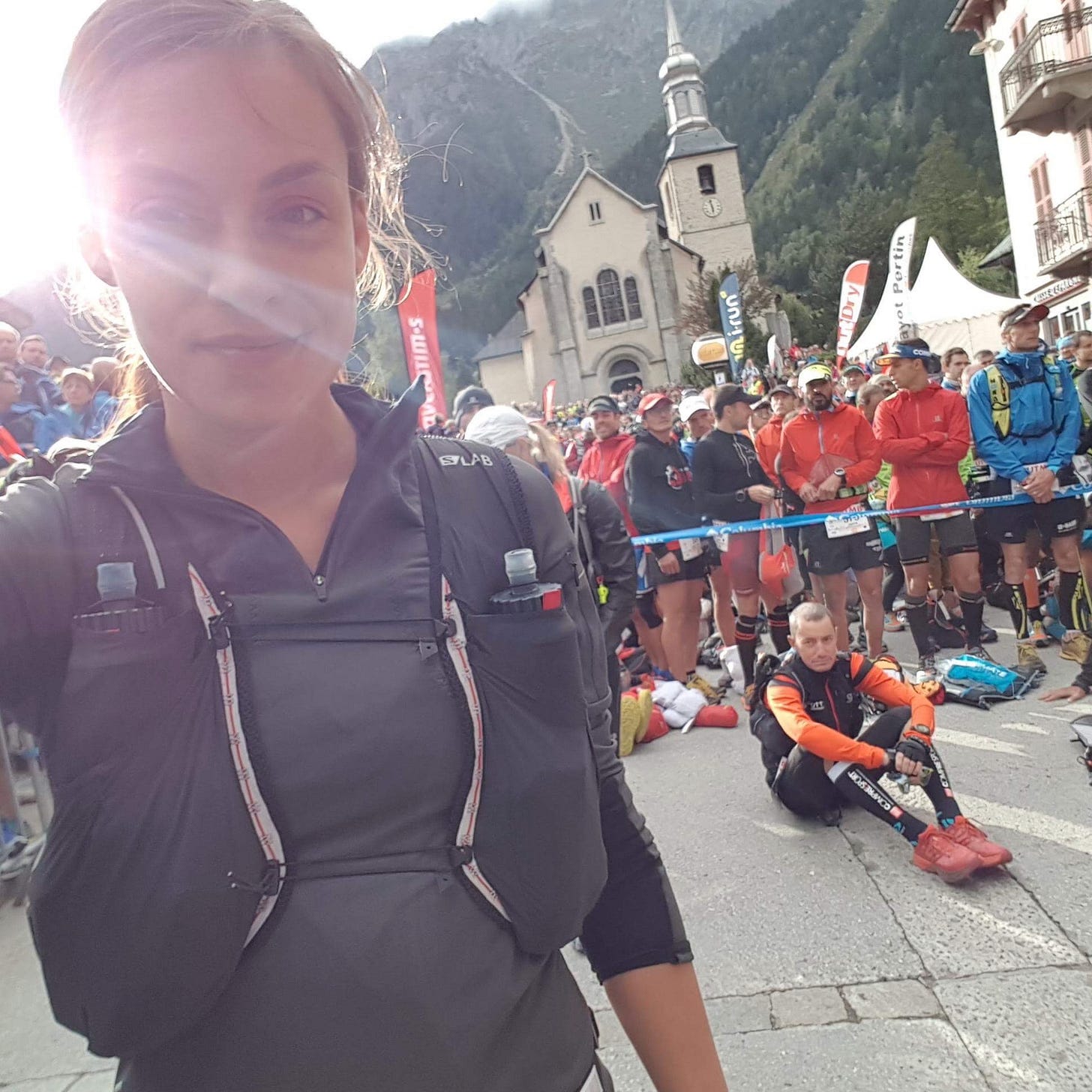 Female runner standing in the sun light at the start of UTMB