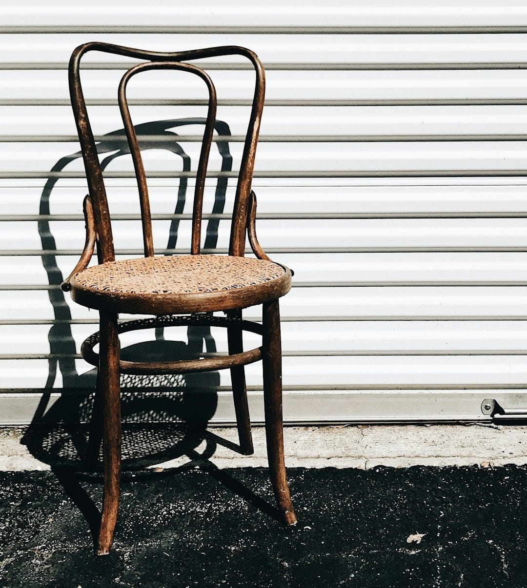 brown wooden chair beside white wall