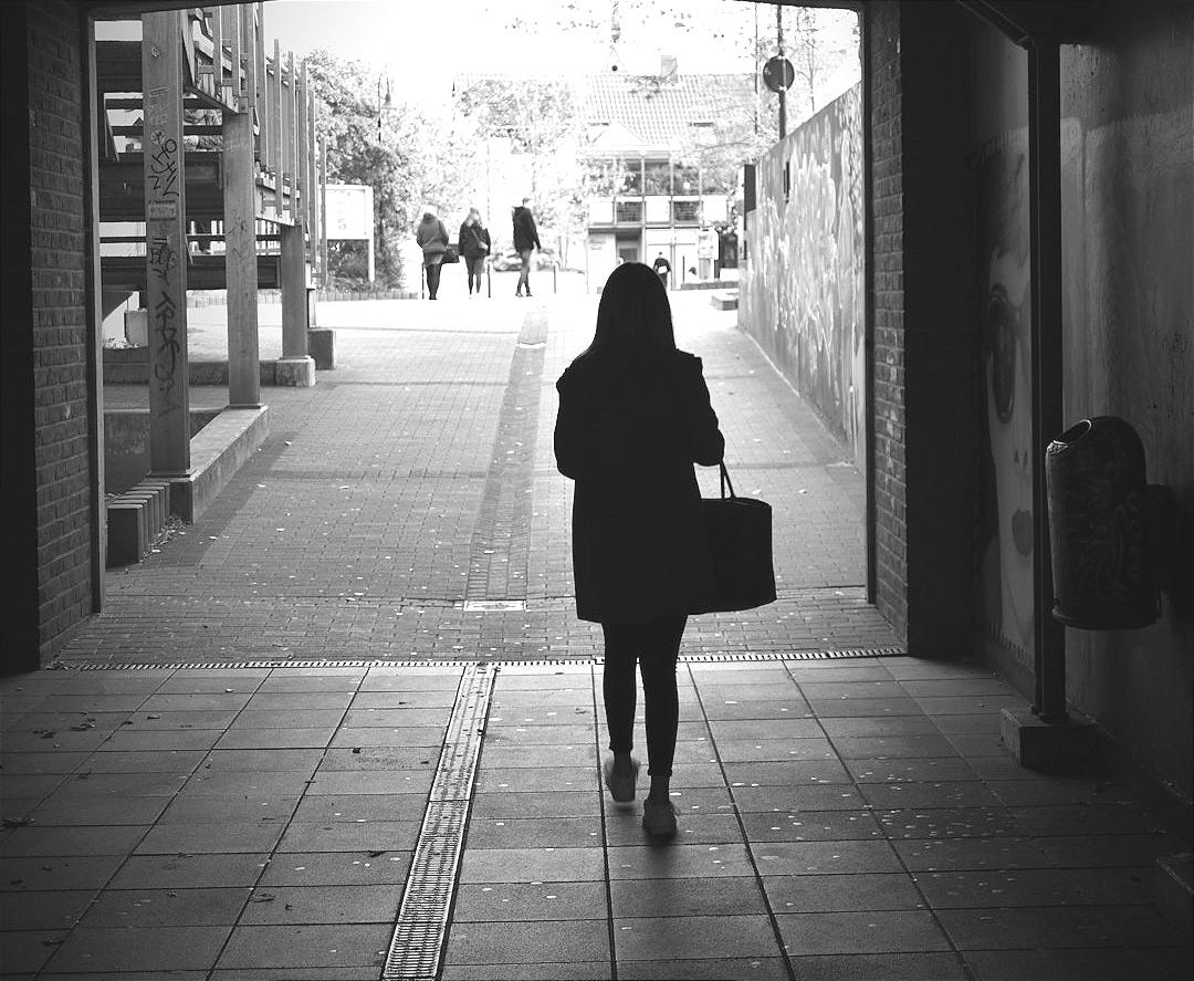 woman standing beside building