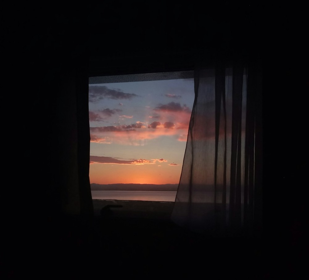 window curtain with view of sea water during sunset