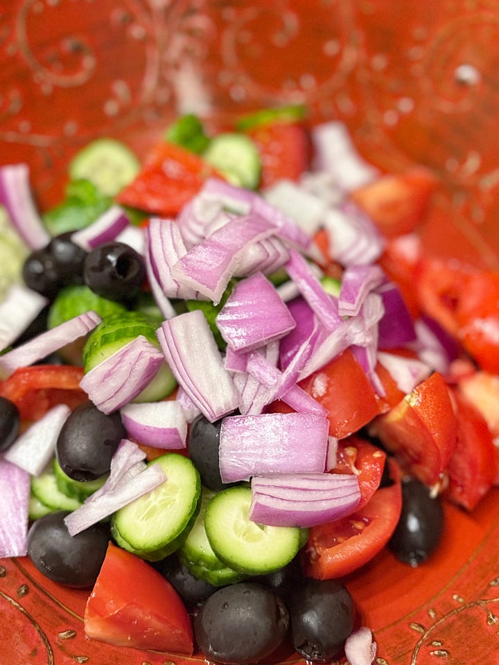 L: Bowl of red onions, cucumbers, black olives and tomatoes, R: bowl of cucumbers, black olives, red onions, tomatoes and crumbled feta cheese