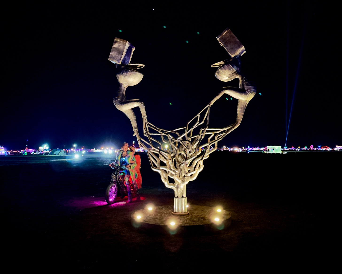 Photo of an art installation featuring two metal toilets whose plumbing entwines into a tree-like structure in the shape of a heart. Yes, it's weird.