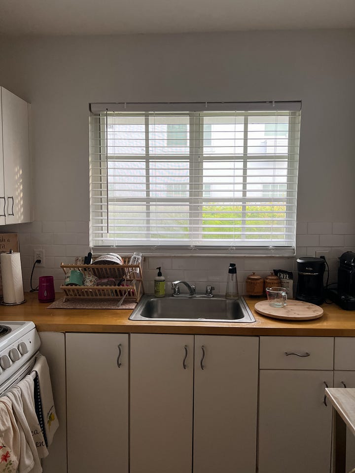 Two photos of the same kitchen window about the sink, with the photo on the left showing a deep midnight blue light outside, before sunrise, and the photo on the right showing a golden yellow and white light after sunrise.