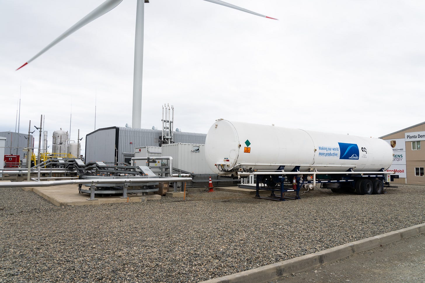 A wind turbine behind a tanker of CO2 at Porsche's prototype factory.