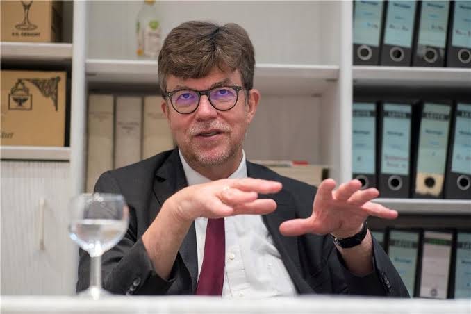 A person in a suit and tie
Description automatically generated A person in a suit and tie
Description automatically generated