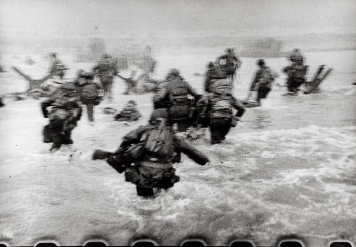 A blurry picture of American men moving through the water to the beach. A blurry picture of American men moving through the water to the beach.