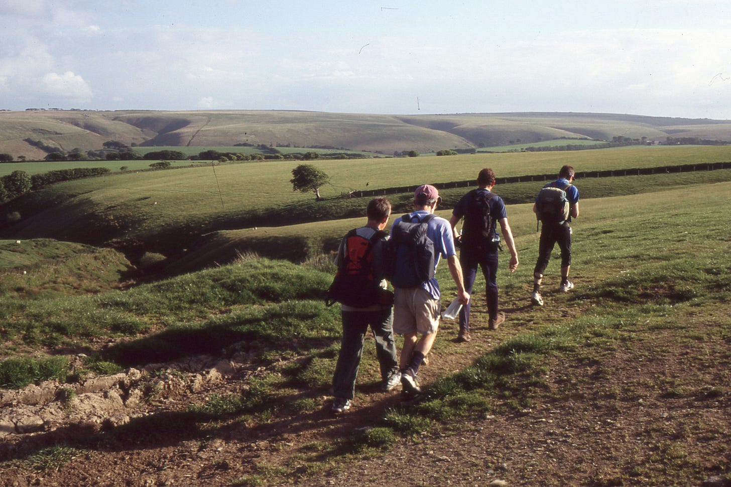 four walkers, grassy moorland ahead