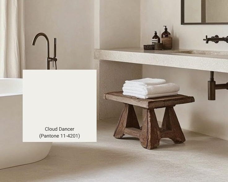 This may contain: a white bath tub sitting under a bathroom mirror next to a sink and a wooden bench