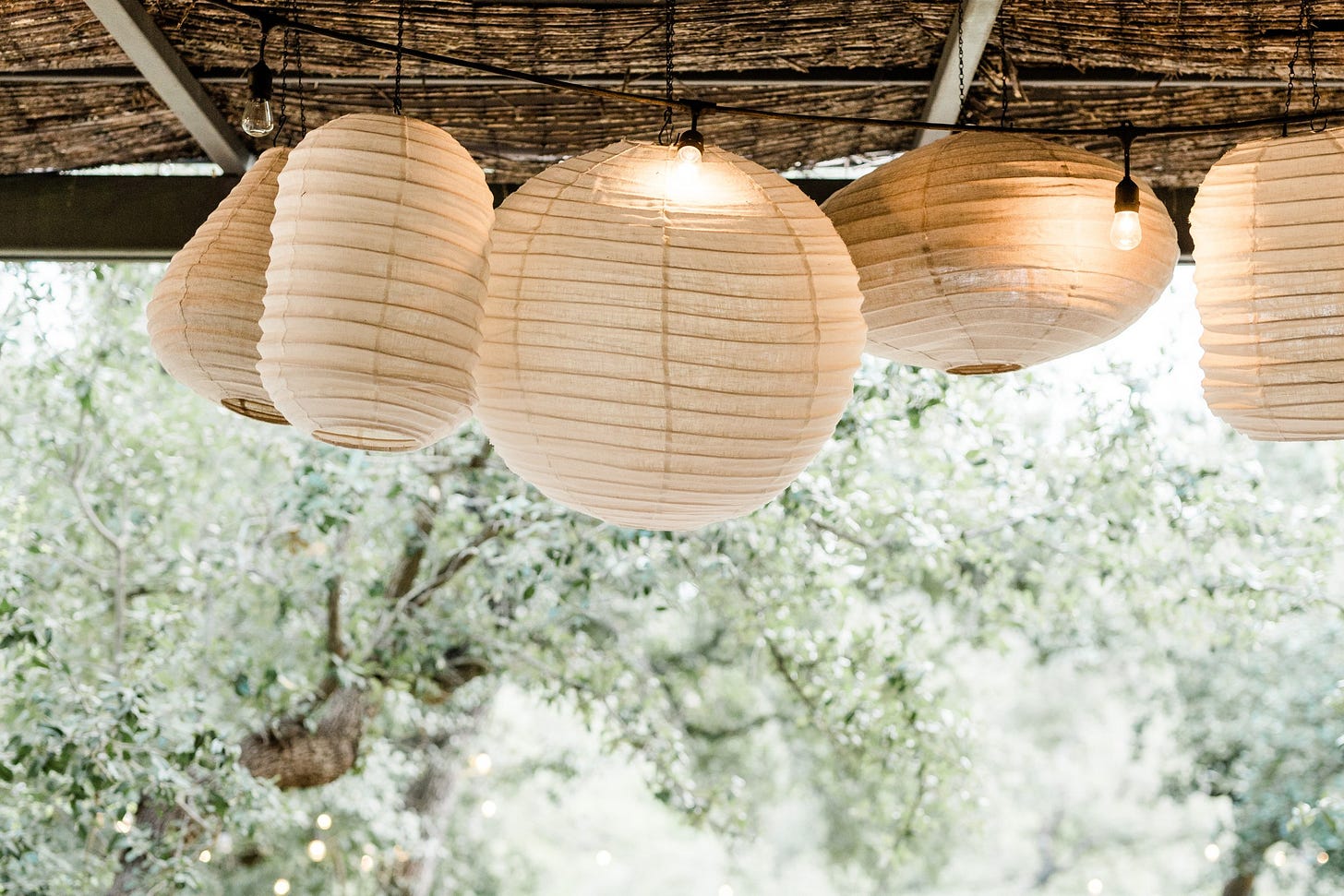A long table under paper lanterns on the café patio at The Wayback