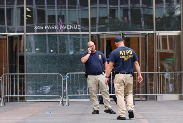 NYPD officers on Tuesday worked near the scene of a deadly mass shooting in Midtown Manhattan. NYPD officers on Tuesday worked near the scene of a deadly mass shooting in Midtown Manhattan.