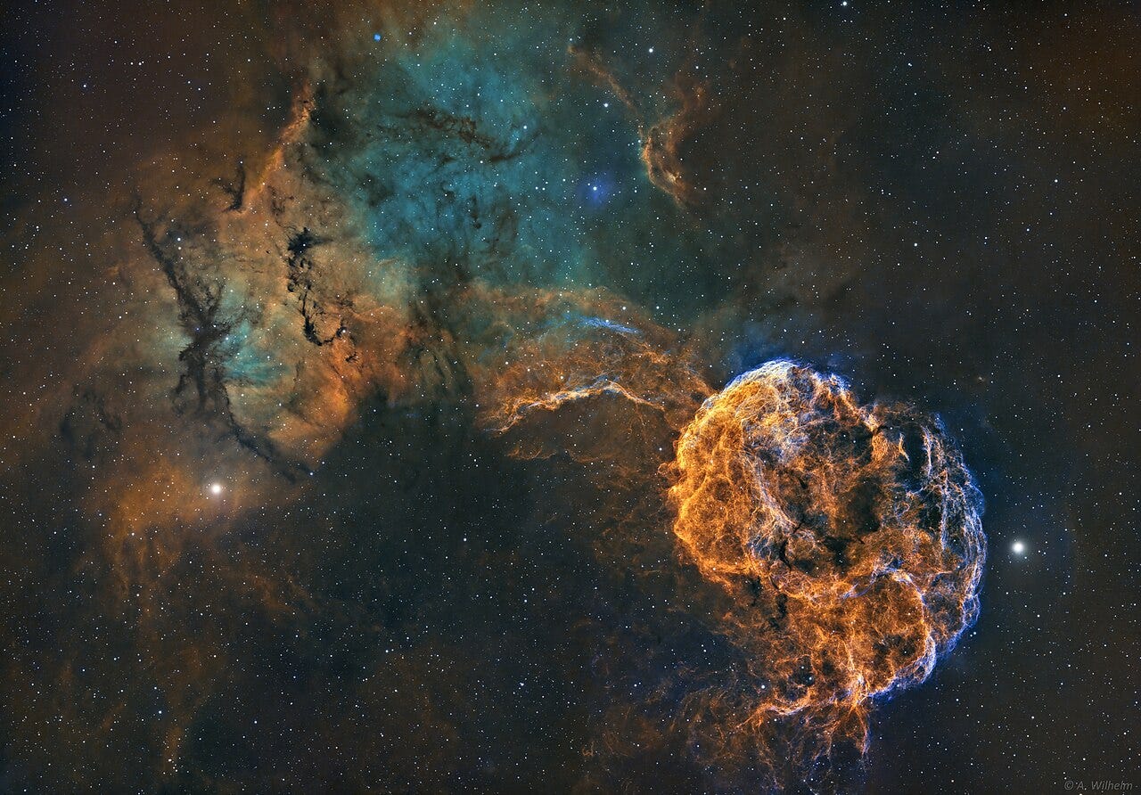 Colorful nebula and star field in space, with bright orange and blue wisps forming a circular shape on the right and a greenish cloud structure on the left, set against a dark background, where once separated stars appear to have reunited amidst the glowing aftermath of ancient supernovae. Colorful nebula and star field in space, with bright orange and blue wisps forming a circular shape on the right and a greenish cloud structure on the left, set against a dark background, where once separated stars appear to have reunited amidst the glowing aftermath of ancient supernovae.