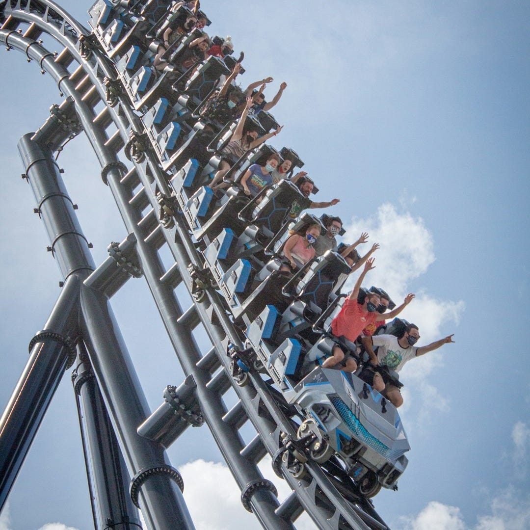 people riding on roller coaster during daytime