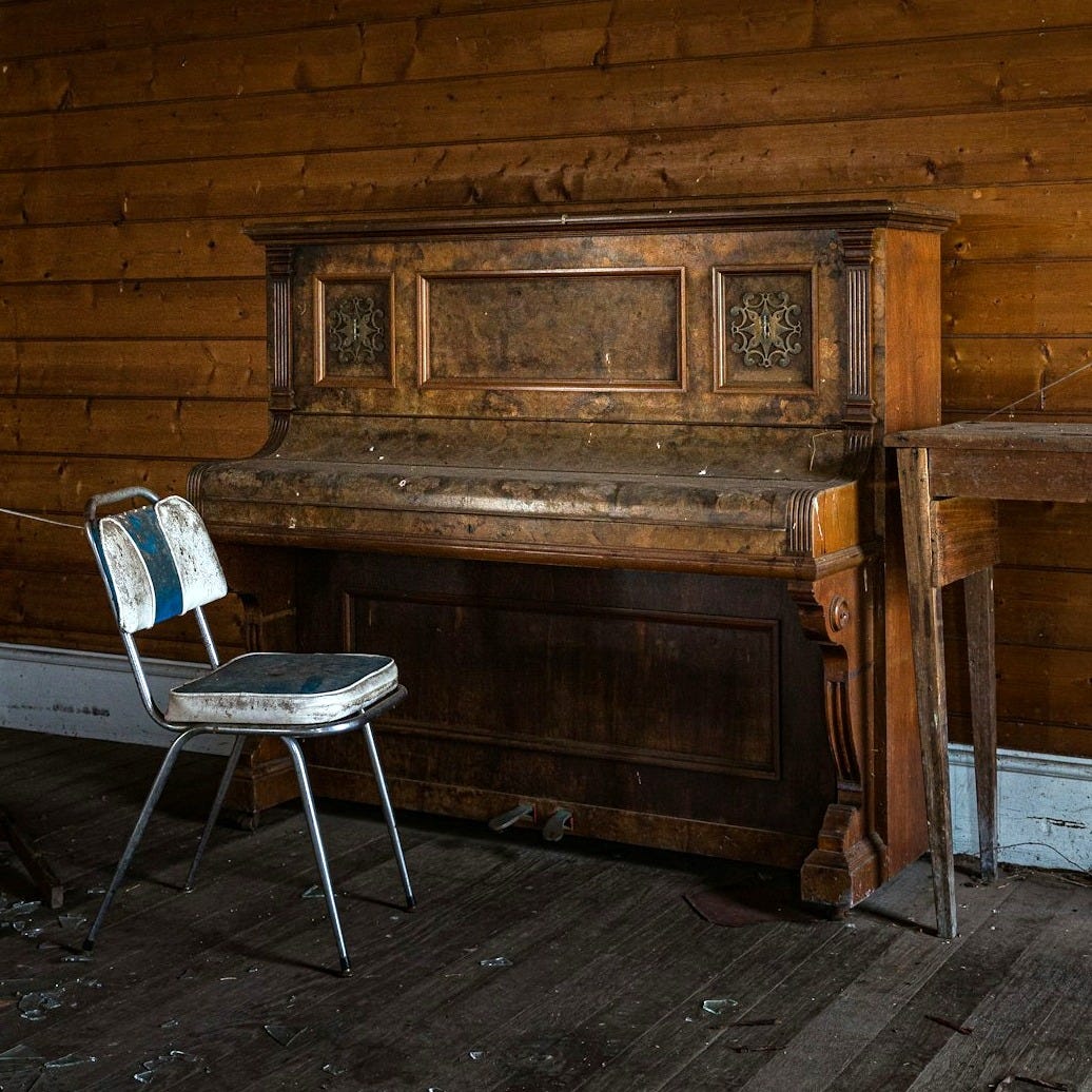 brown wooden upright piano beside brown wooden wall