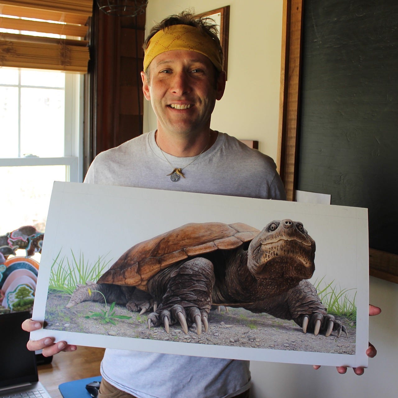 A person holding a picture of a turtle

Description automatically generated