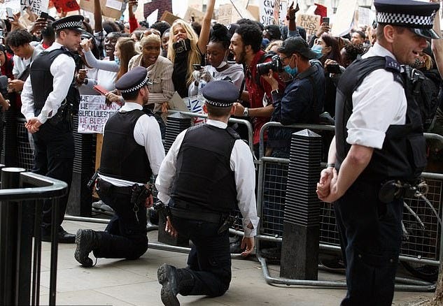 British police officers take the knee before aggressive black mobs