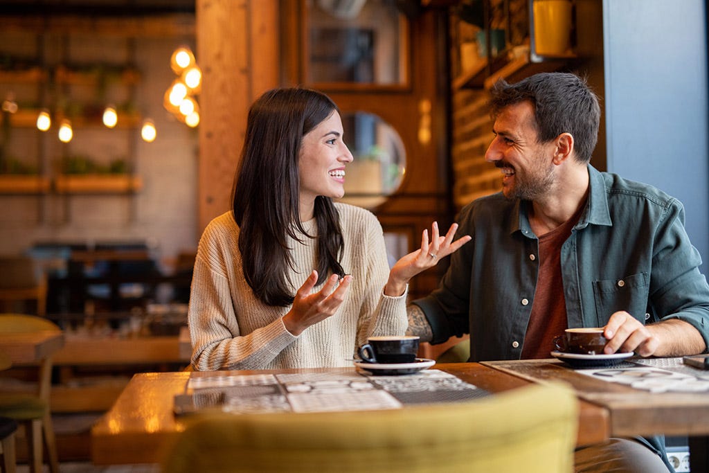 An Indian couple having a heartfelt conversation over coffee, discussing life goals and future visions before their wedding day.