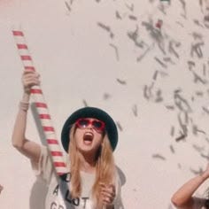This may contain: two women are holding up candy canes and confetti in front of them