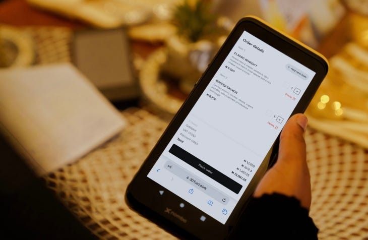 hand holding smartphone displaying Nomba app