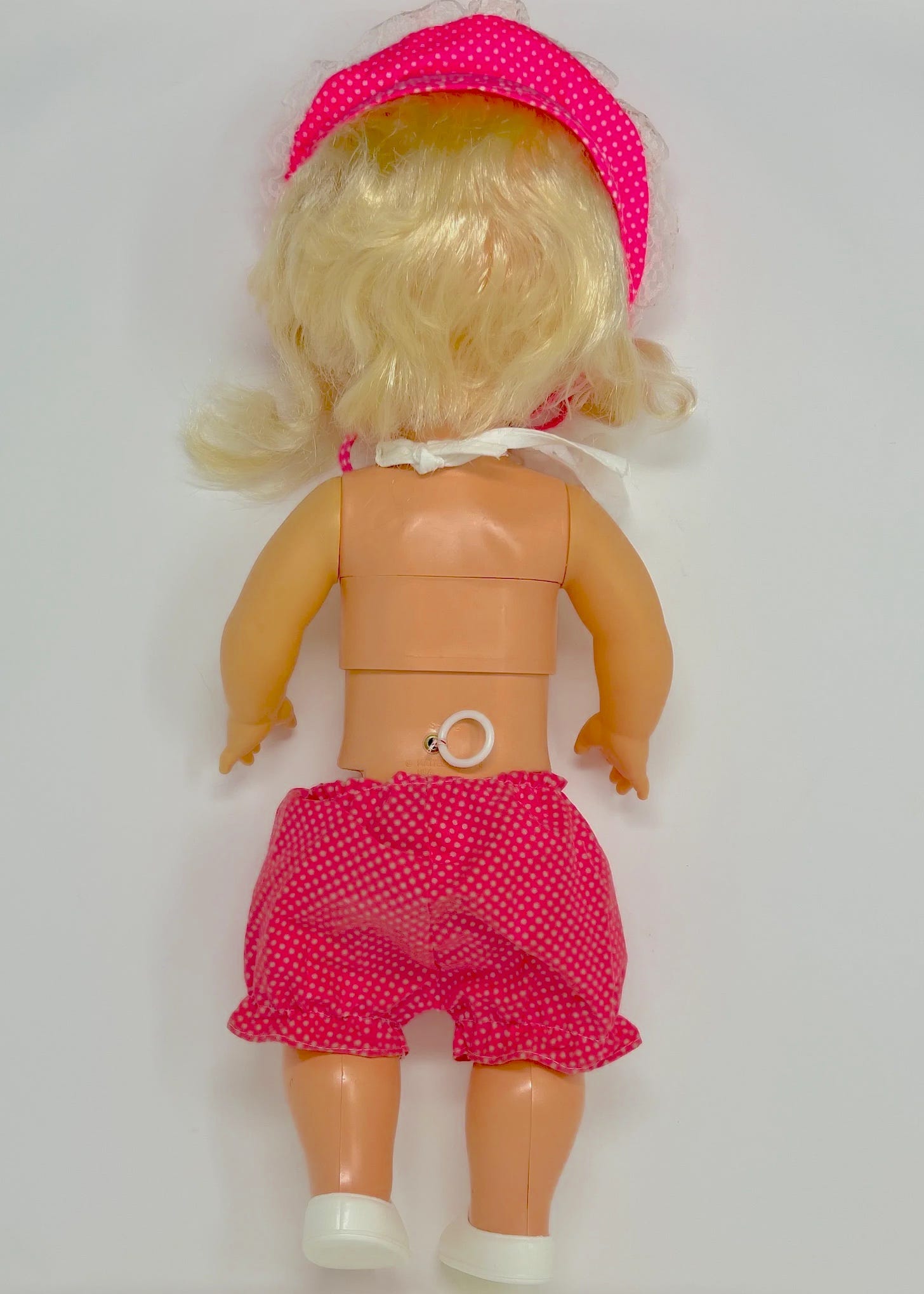 back of the doll showing the cord that comes out of the lower back, with a little round handle to tug on it. 