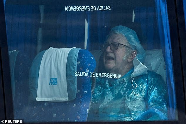 A passenger of the cruise ship MV Hondius sits with his mask off on a bus on the way to the airport, at the port of Granadilla de Abona, in Tenerife, Spain, May 10