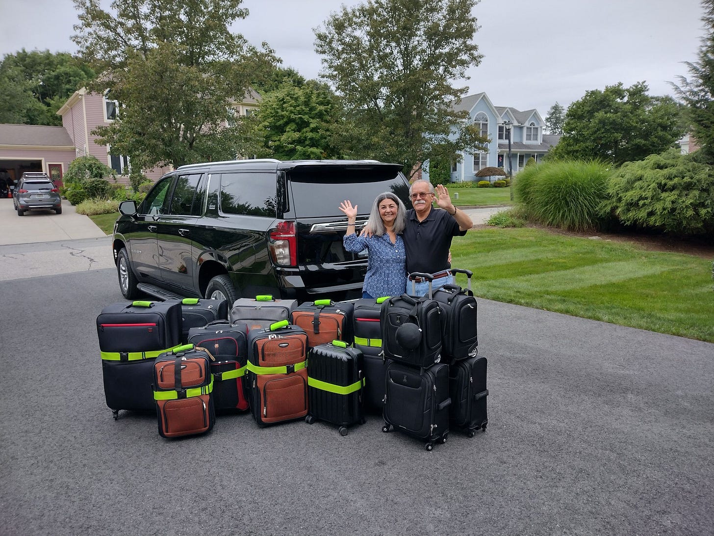 Couple waving with suitcases Couple waving with suitcases