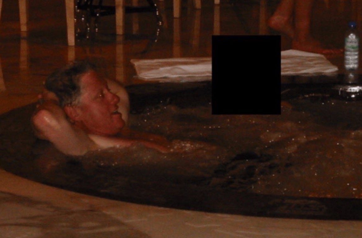Man relaxing in a hot tub with a serene expression, surrounded by a tranquil indoor setting.