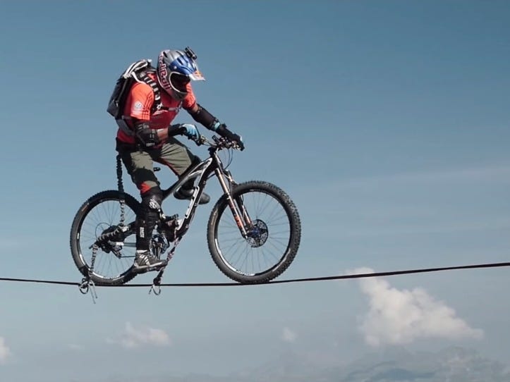 Man Rides a Bike Over a Tightrope Between the French Alps Man Rides a Bike Over a Tightrope Between the French Alps