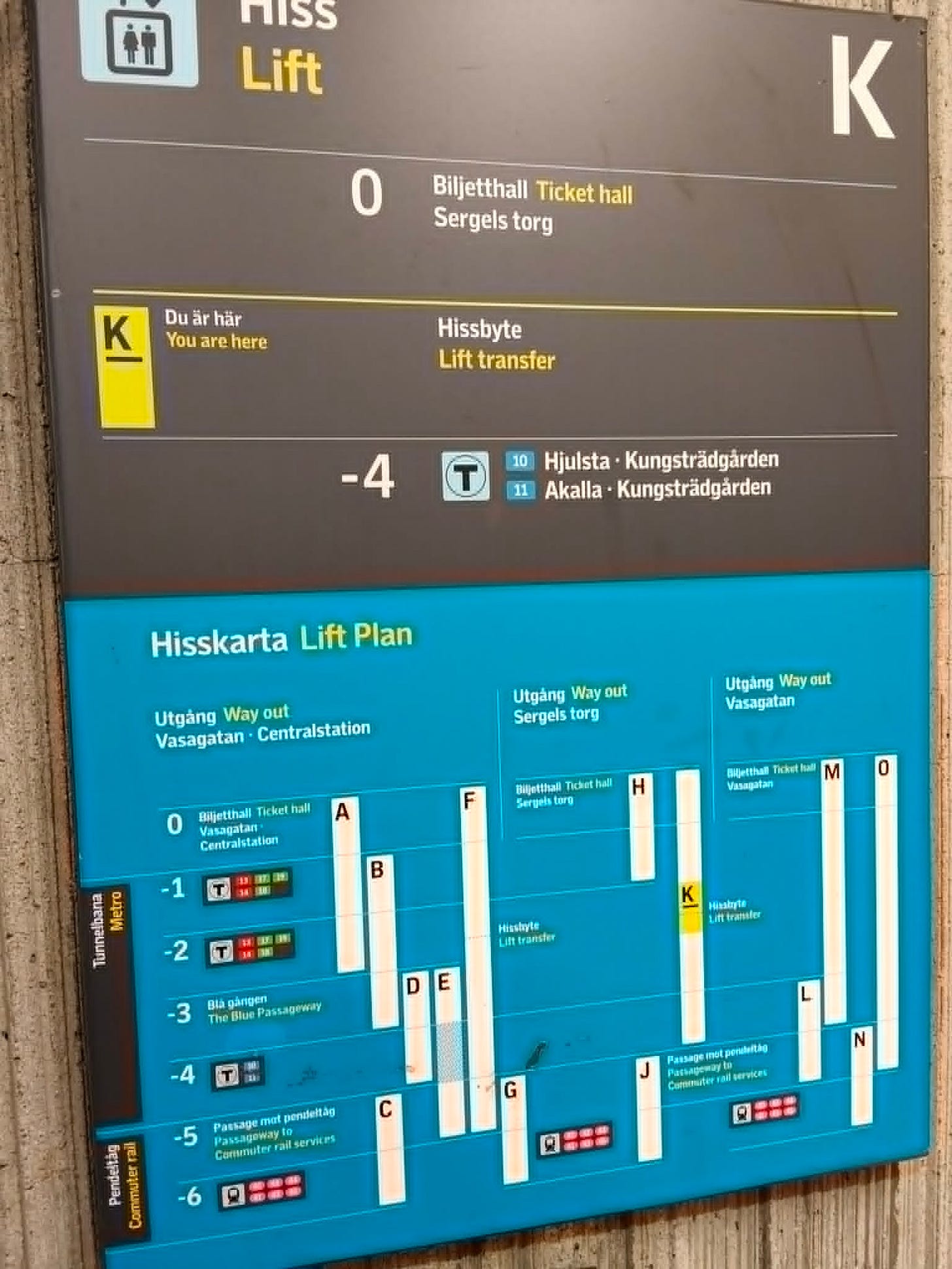 Elevator sign in a station shows a floor plan and routes. It includes lift and exit details, floor numbers, and wayfinding for tickets and transfers.