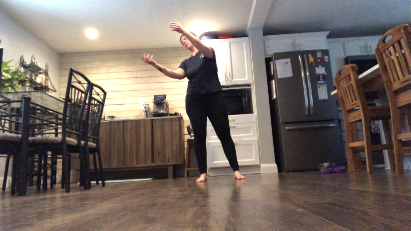 A person dances in a kitchen.