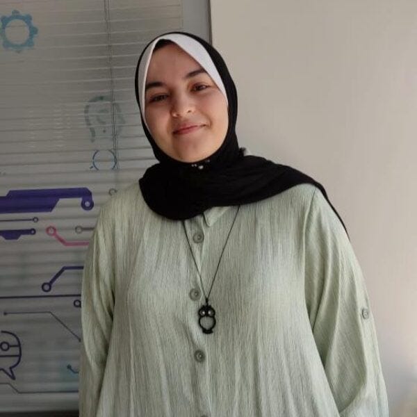 Smiling young woman in white dress and black hijab with white headband. Smiling young woman in white dress and black hijab with white headband.