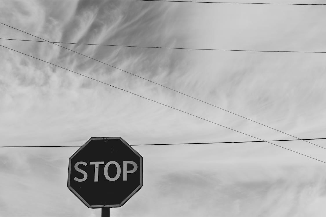 Free Grayscale Photography of Stop Signage Under Sky Stock Photo