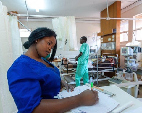 A nurse writes a report with a pen in a hospital ward
