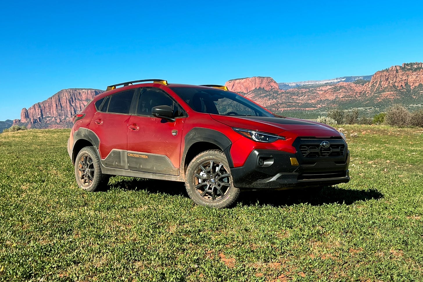 A red 2024 Subaru Crosstrek Wilderness parked on a grassy mesa near Zion National Park.