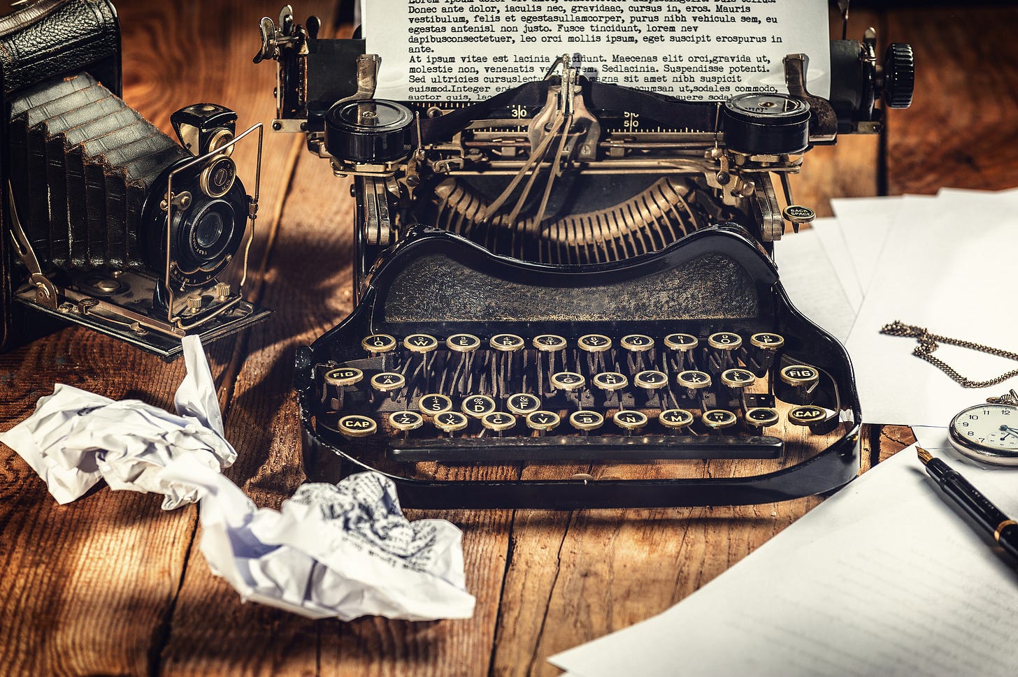 antique typewriter on wood table with crumpled paper around