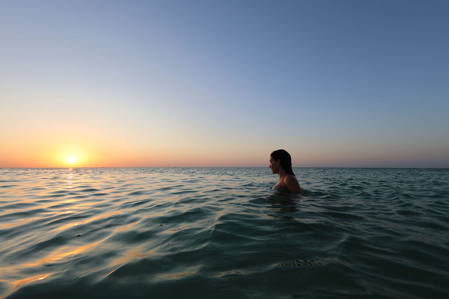 Frau im Wasser bei Sonnenuntergang Frau im Wasser bei Sonnenuntergang