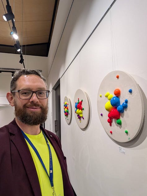 The first part of a multi-gallery photographic series documenting the Cinis Ardor Vitae art exhibition, showcasing light-reactive copper artwork, portraits of artist Michal Plis, and scenes from the venue.