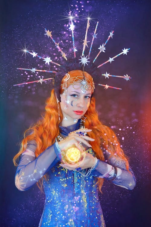 Free Young female astrologist predicting future with shining ball Stock Photo