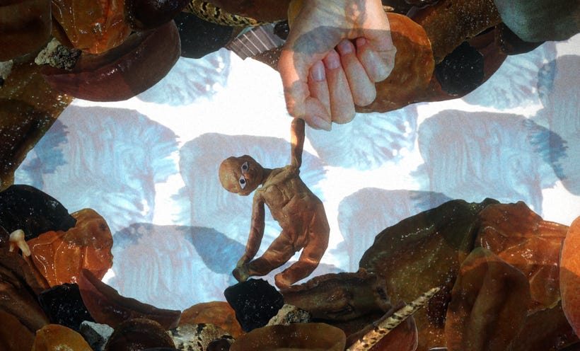A photographic human fist pulls on a doll made of clay