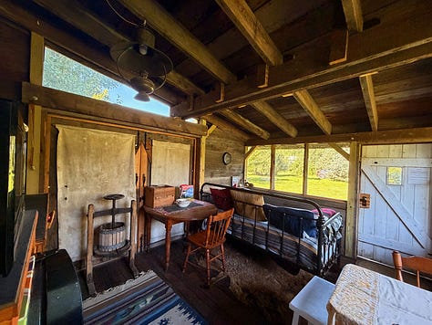 Two books, The Birchbark House and On the Banks of Plum Creek, rest on the cabin’s daybed. | The interior of the Airbnb shows a small kitchen table, old Pioneer kitchen mixers, and canvas used as curtains. | A kid with colorful toe nail polish, washes her feet in a tin bucket with a tin ladle.
