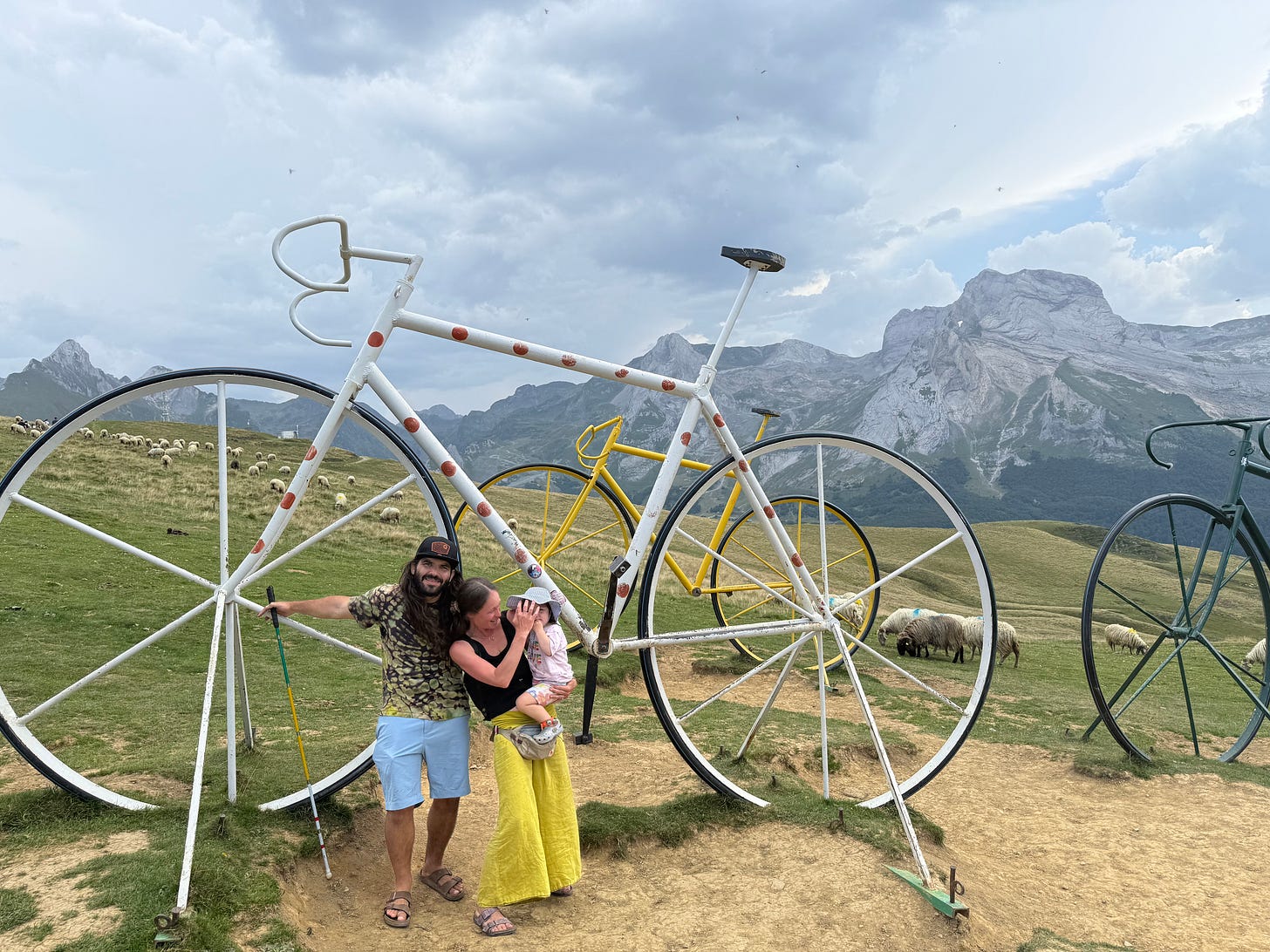anthony his wife and daughter in front of the famous bikes that stand on the summit of Col d'Aubisque