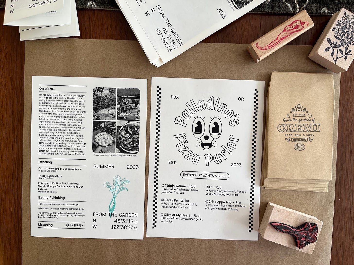 A spread of the zine, menu, stamps and seed packets
