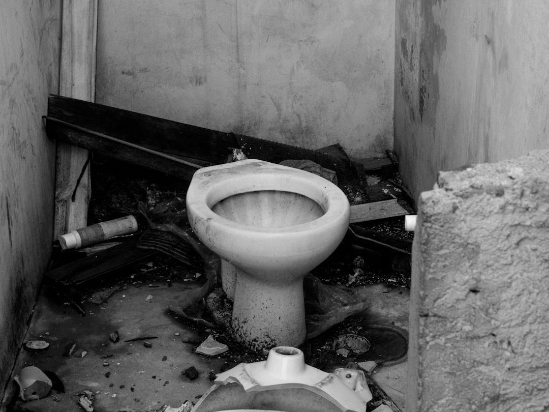 a dirty bathroom with a broken toilet in it a dirty bathroom with a broken toilet in it