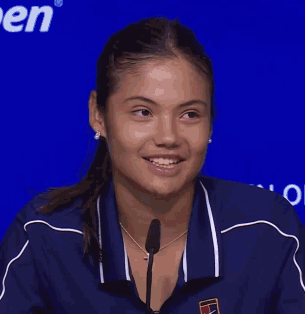 a woman wearing a blue nike shirt is smiling