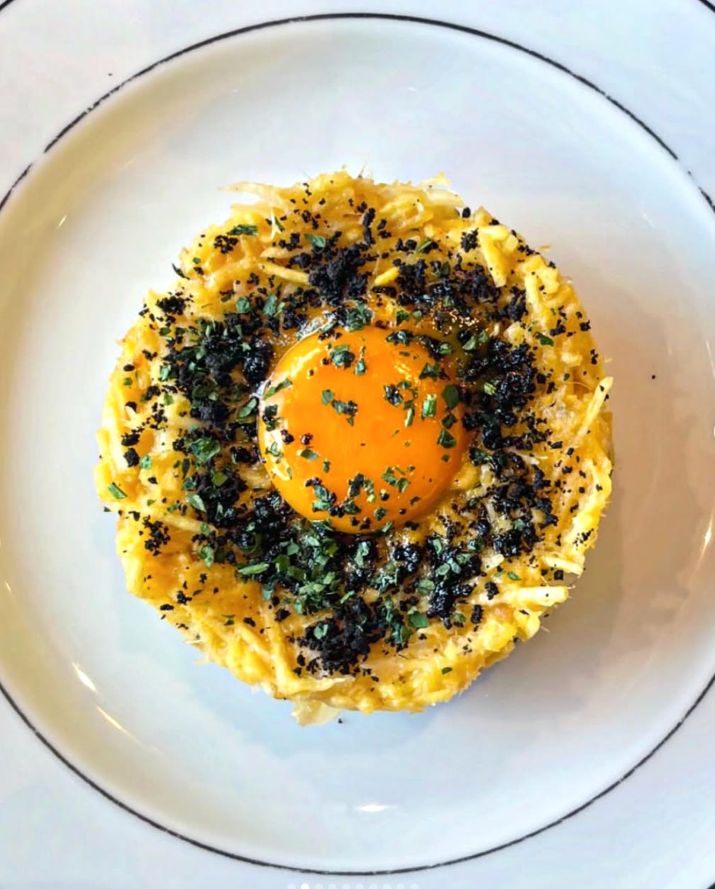 “Plate of Bacalhau à Brás with soft egg and parsley.”