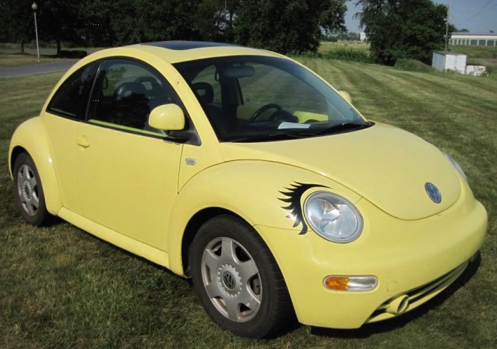 a bright yellow VW beetle with black eyelashes over the headlights.