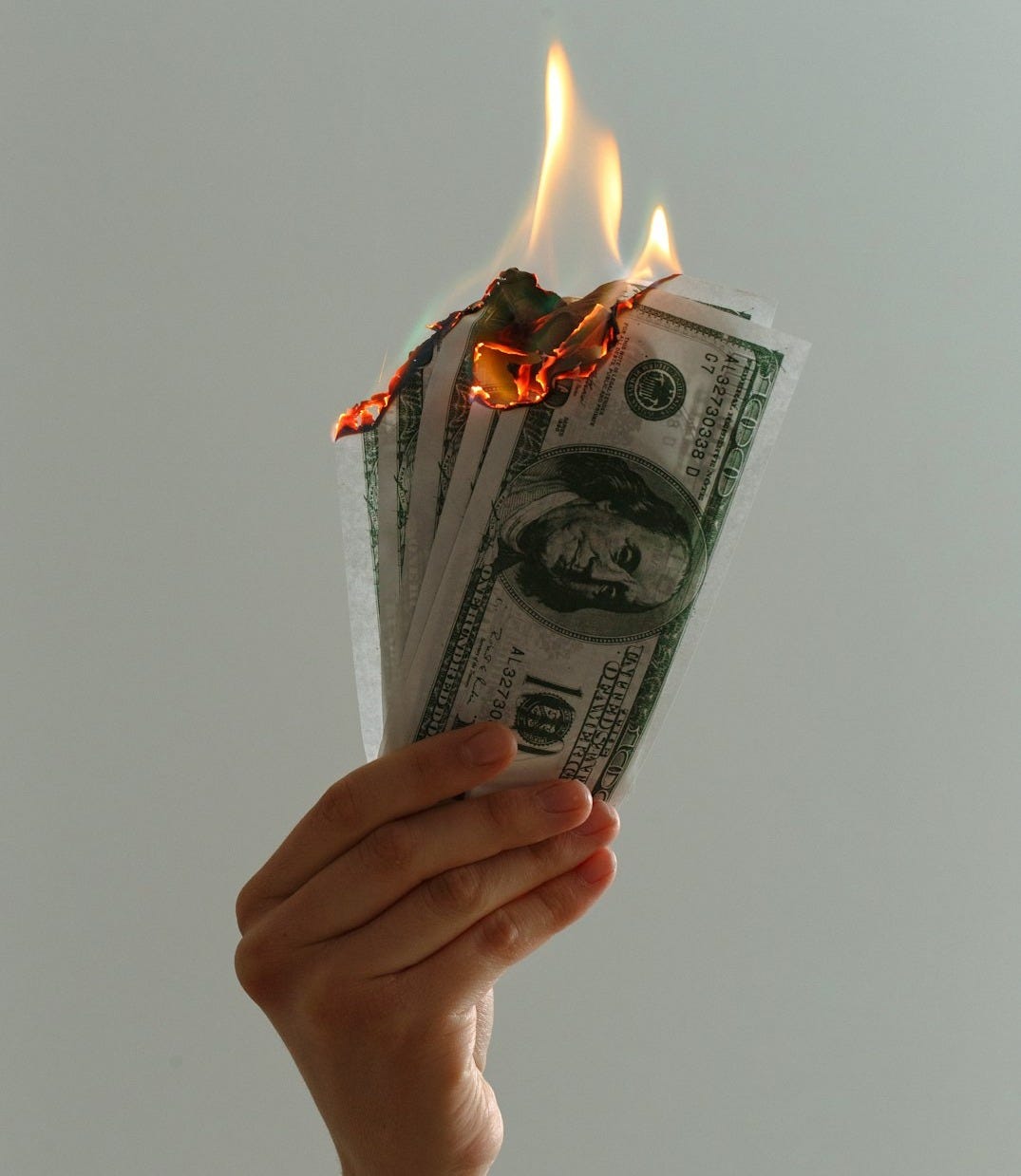 time lapse photography of several burning US dollar banknotes