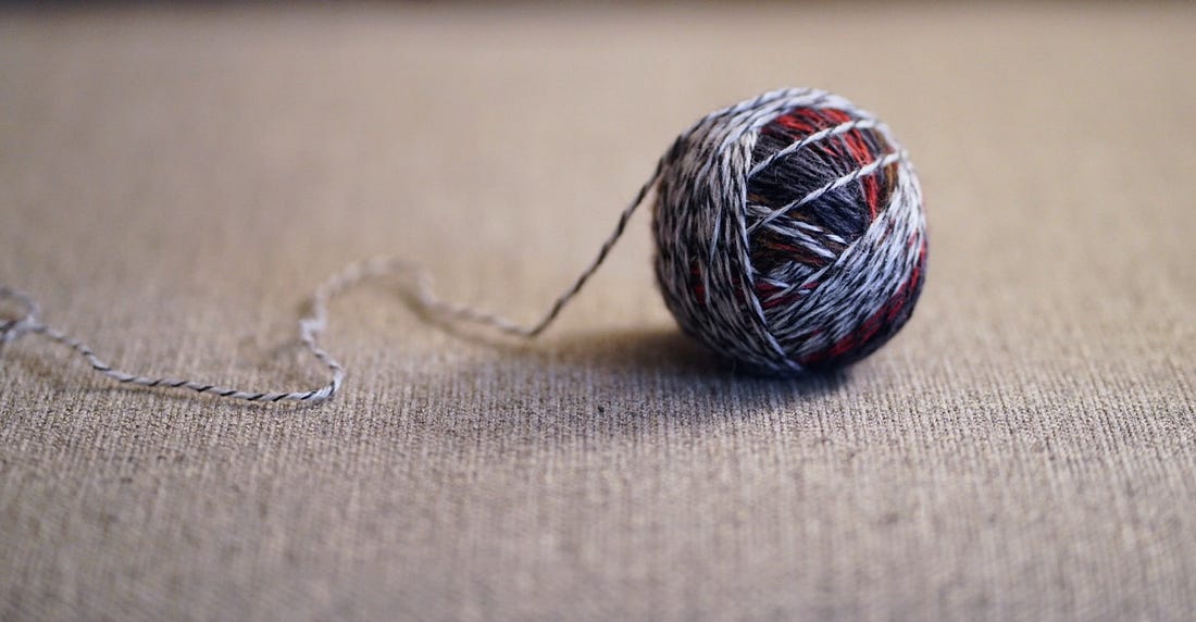 A ball of variegated blue, gray, and red yarn A ball of variegated blue, gray, and red yarn