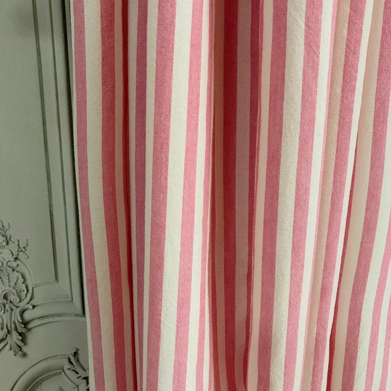 May include: Close-up of pink and white striped fabric. The fabric is a cotton blend and has a soft, textured feel. The stripes are evenly spaced and create a classic, timeless look.